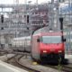a red and silver train traveling down train tracks