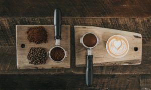 coffee beans beside coffee powder on brown wooden board