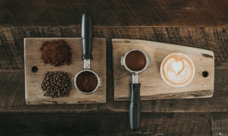 coffee beans beside coffee powder on brown wooden board