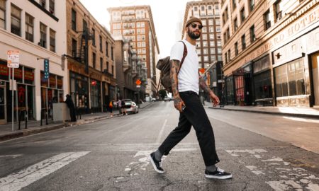 man in white long sleeve shirt and black pants standing on road during daytime