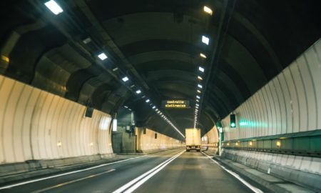 gray and white tunnel with lights turned on during night time