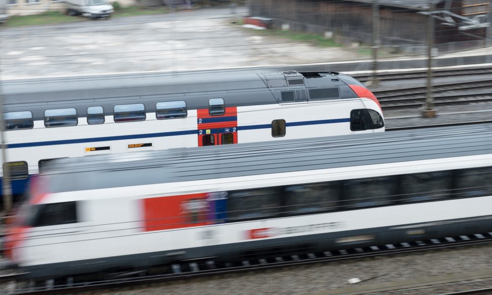 a train traveling down train tracks next to a building