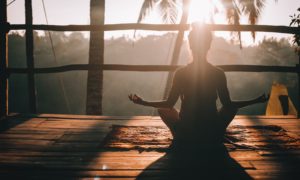 woman in black tank top sitting on brown wooden dock during daytime